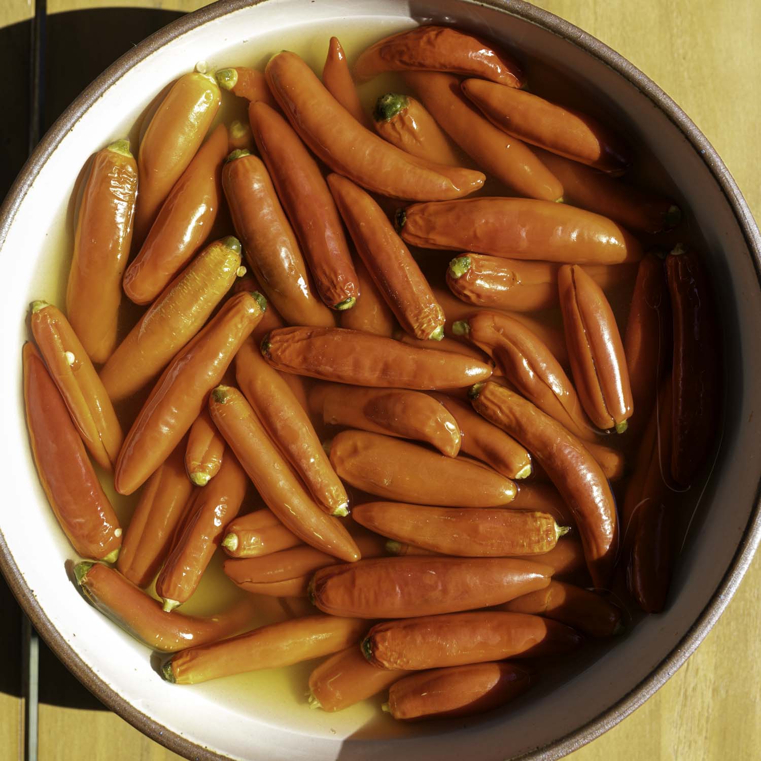 Closeup of salted, pickled chiles in a bowl.