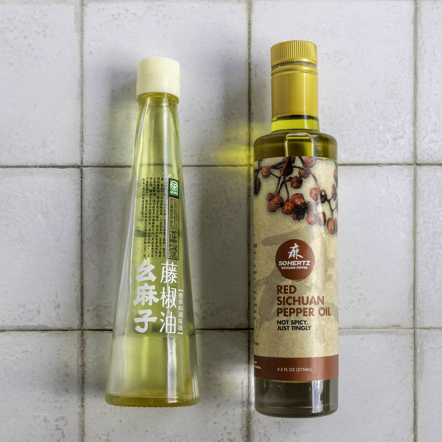 A bottle of green and red Sichuan pepper oil resting on their side, label facing up.